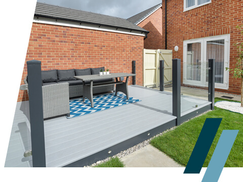 A grey decking area with glass balustrades